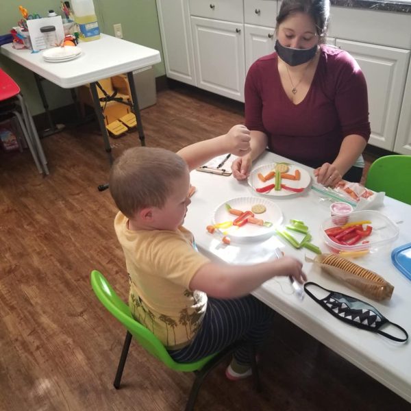 Cassidy Burkholder, OTRL doing food exploration with a young patient.